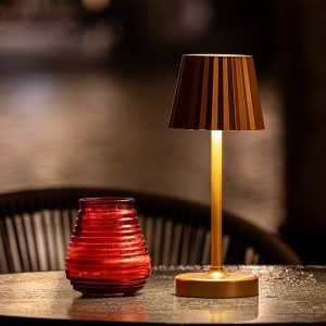 چراغ رومیزی با کلاهک تاشده و نور گرم روی میز